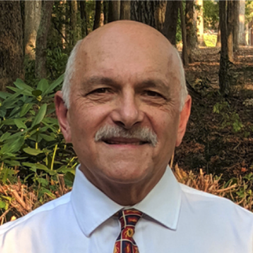 bald man with mustache and a white shirt with a tie